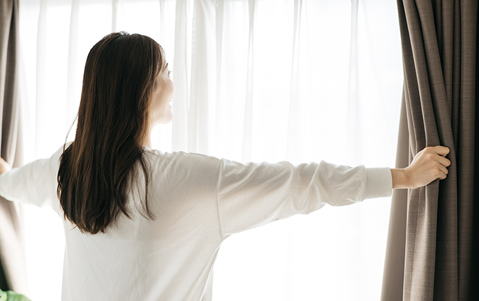 起床する女性の画像